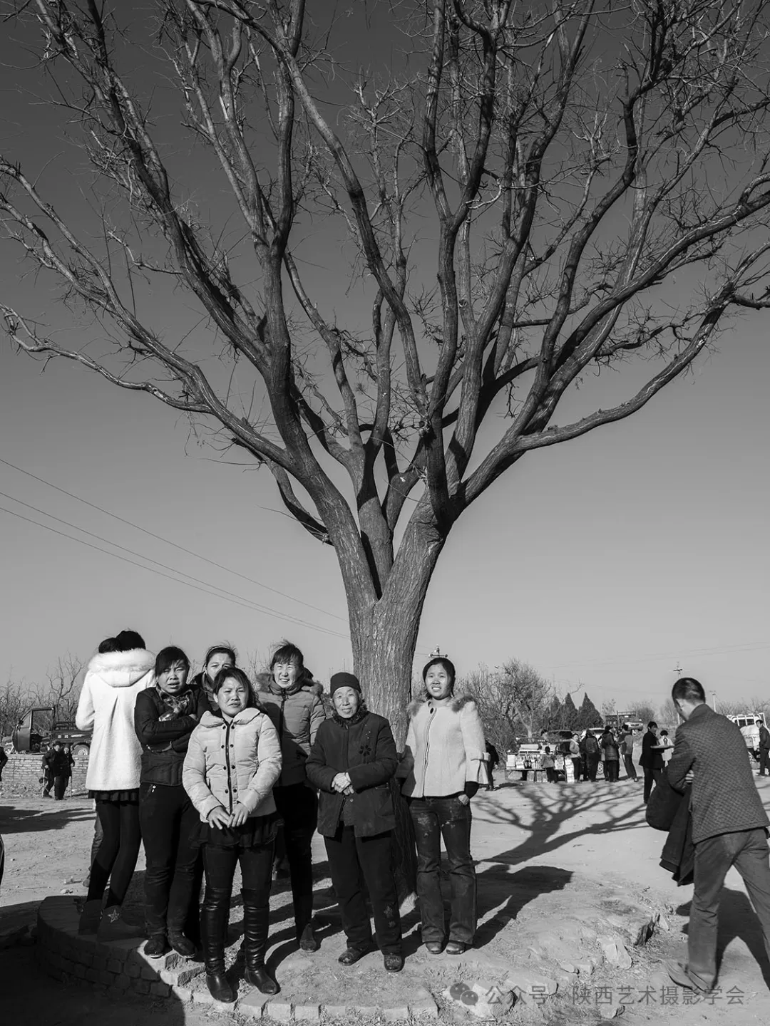 2014年2月3日，延川县桑洼村，村头大树下，春节后回村的媳妇们陪婆婆看“闹红火”。
