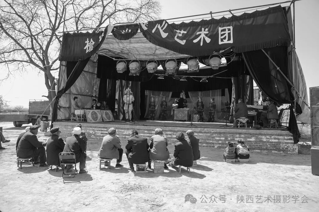2010年3月28日，延川县北塬村，留守在村里的老人与儿童在看大戏。
